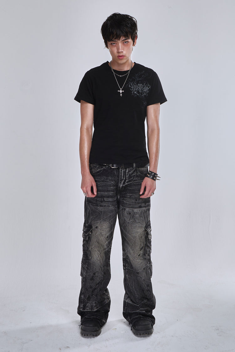 Model wearing the washed black Fractured Denim cargo jeans with a black tee, full-length view