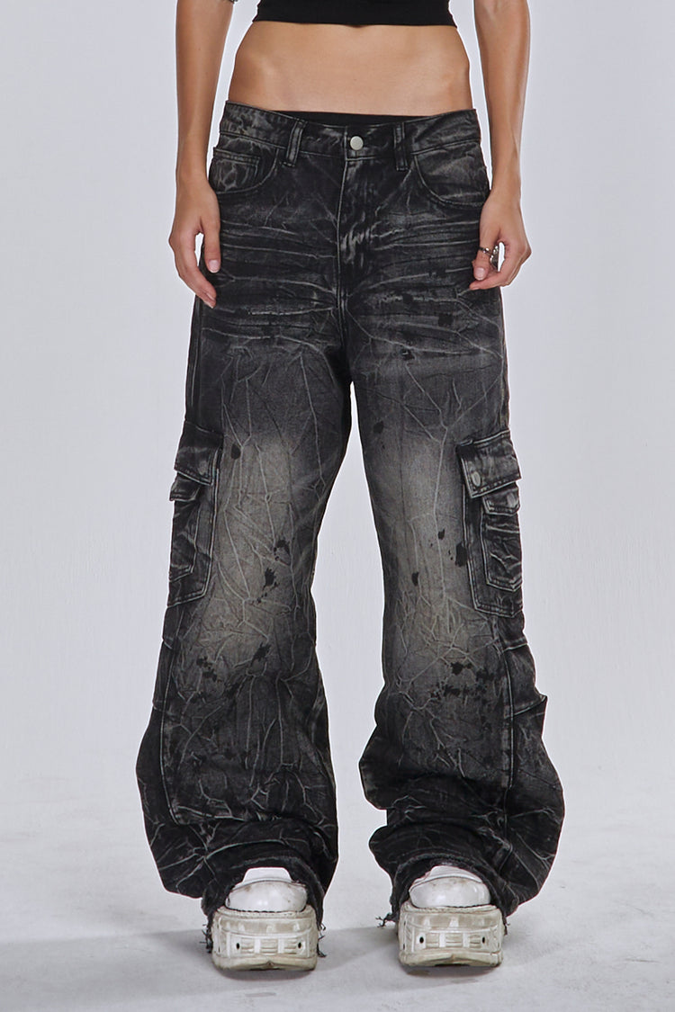 Front view of the Fractured Denim, washed black cargo jeans with crinkle distressing, worn low