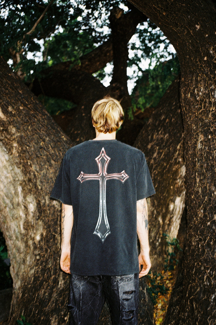 Back view of the Cross Tee worn outdoors between large tree trunks