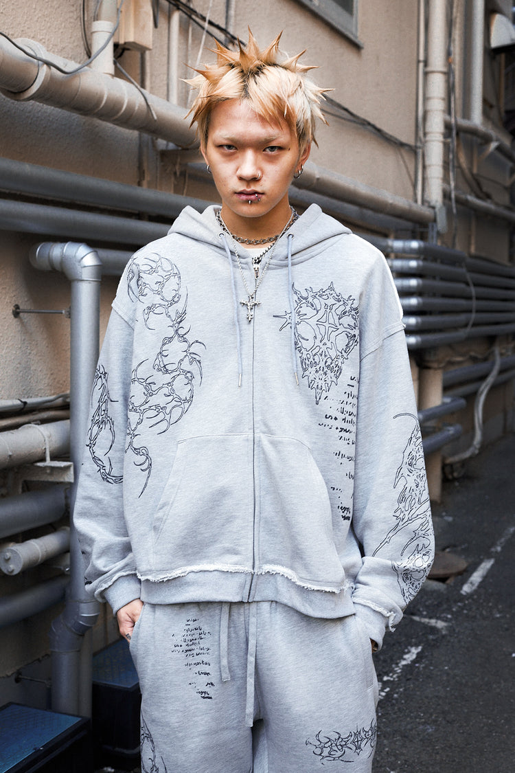 Model with spiky bleached hair in the Gray Sigil Zip Hoodie on a city street