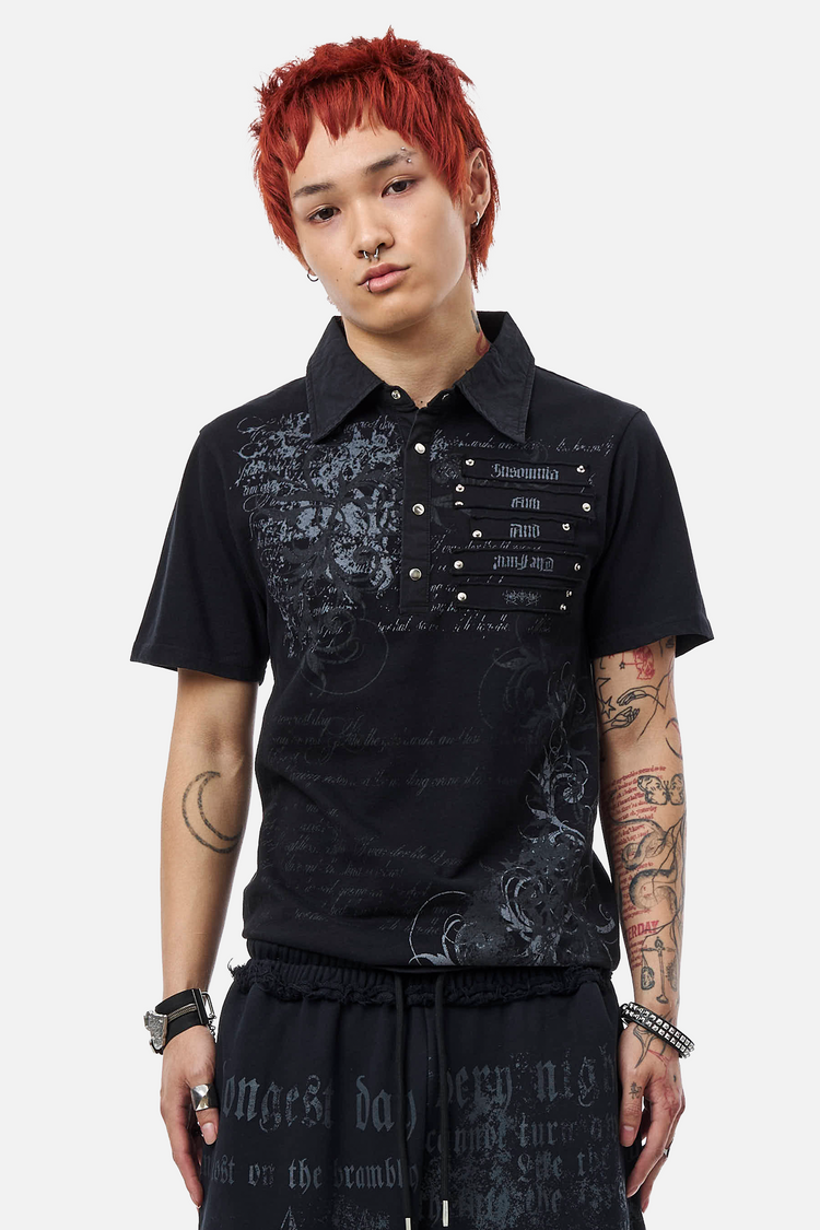 Model wearing the Black Thorns Polo with gothic script print and studded chest panel, front view