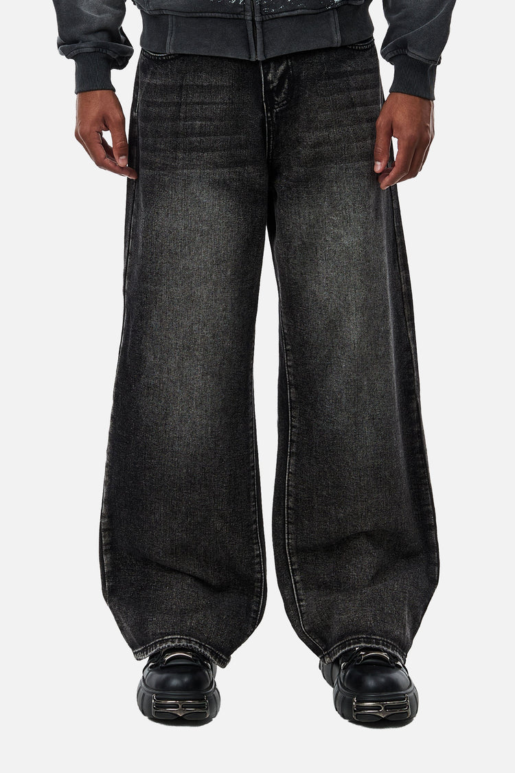 Front view of the Washed Black Outlaw Denim, a baggy faded fit with black chunky shoes