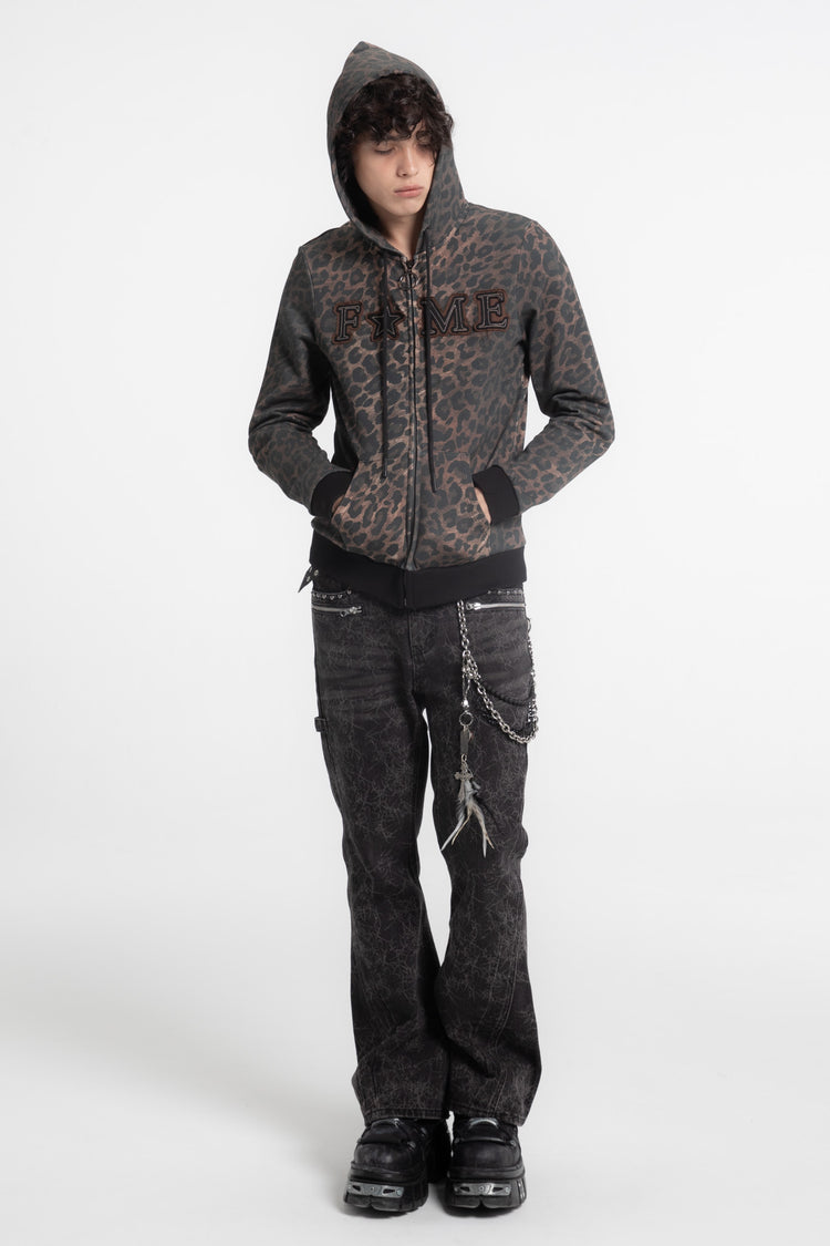 Model in the FAME Slim Zip Hoodie with hood up and black flared jeans, full-length view