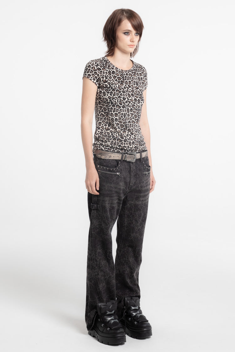 Three-quarter side view of the fitted Cheetah Slim Tee with dark jeans and platform boots