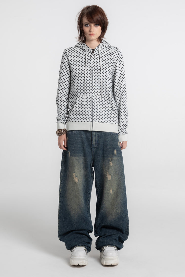 Full-length front view of the Polka Dot Slim Zip Hoodie worn with faded wide-leg jeans