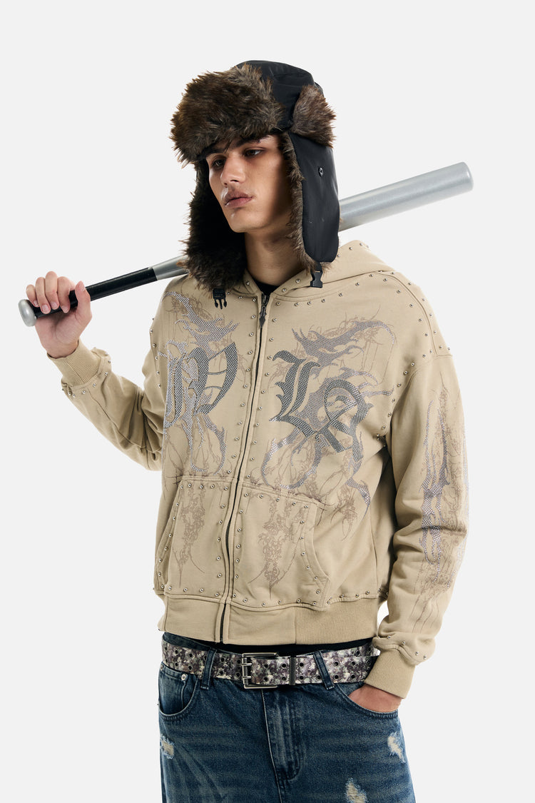 Model in a fur trapper hat holding a bat while wearing the sand IVLA Zip Up Hoodie