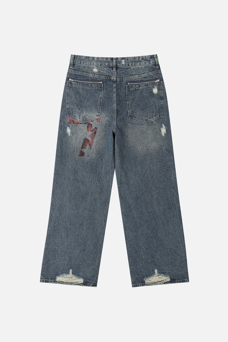 Back of the Patch Outlaw Denim laid flat with red embroidered patch on the back pocket