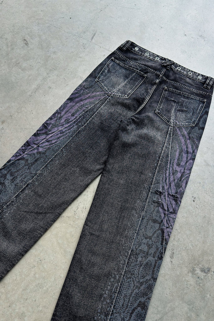 Snakeskin Tribal Destroyer Denim laid flat on concrete