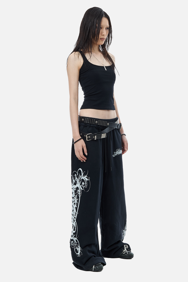 Three-quarter view of the Eternal Sweatpants worn low with layered studded belts