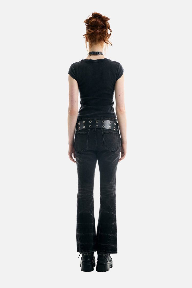 Back view of the black Treasure Tee with grommet belt and flared jeans, full-length