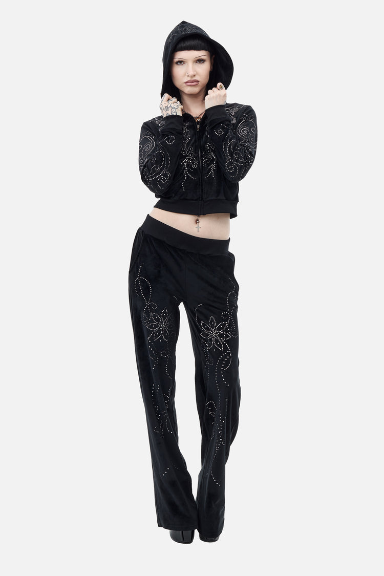 Model holding the hood of the Velour Flutter Hoodie, styled with matching velour pants