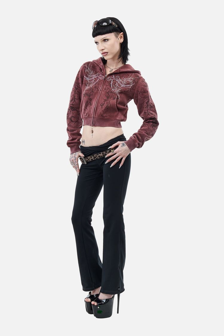 Full-length side pose in the cropped burgundy Fever Hoodie with black flared pants