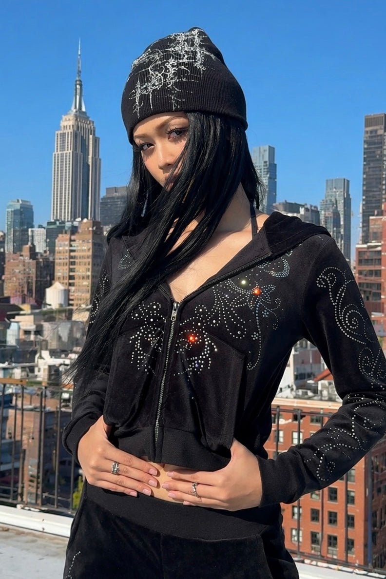 Velour Flutter Hoodie worn with an embellished beanie on a rooftop, front view