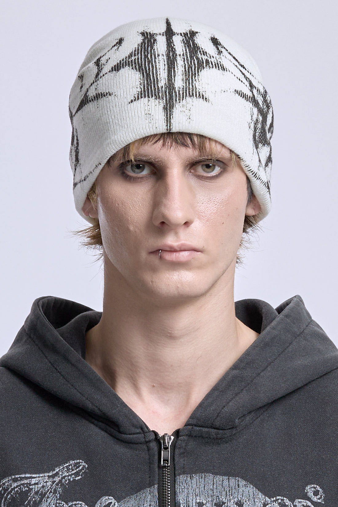 Model wearing the White Glitch Logo Beanie with black glitch logo, front close-up