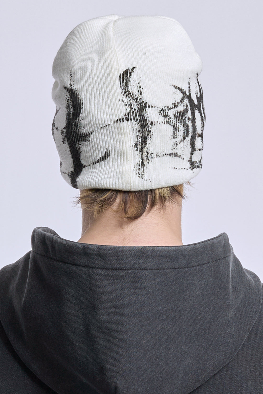 Back view of the White Glitch Logo Beanie on model, black glitch knit around the cuff
