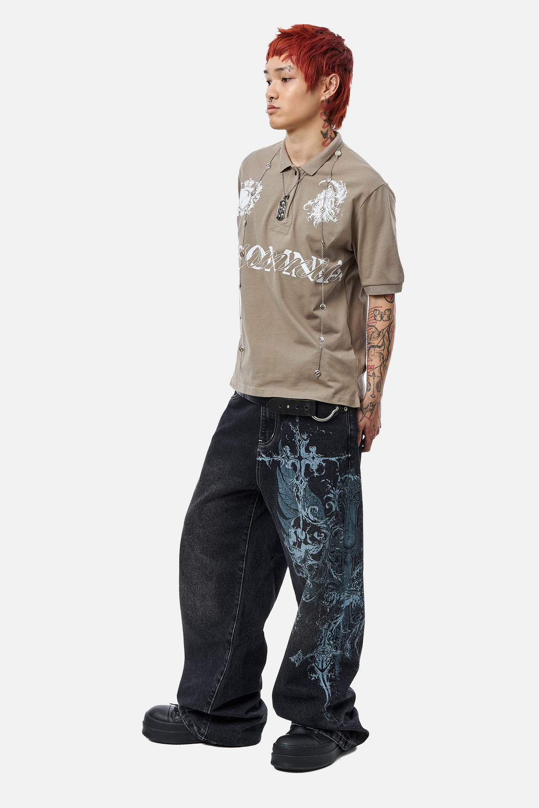 Model in the Winged Outlaw Denim and a tan graphic polo, full-length side view