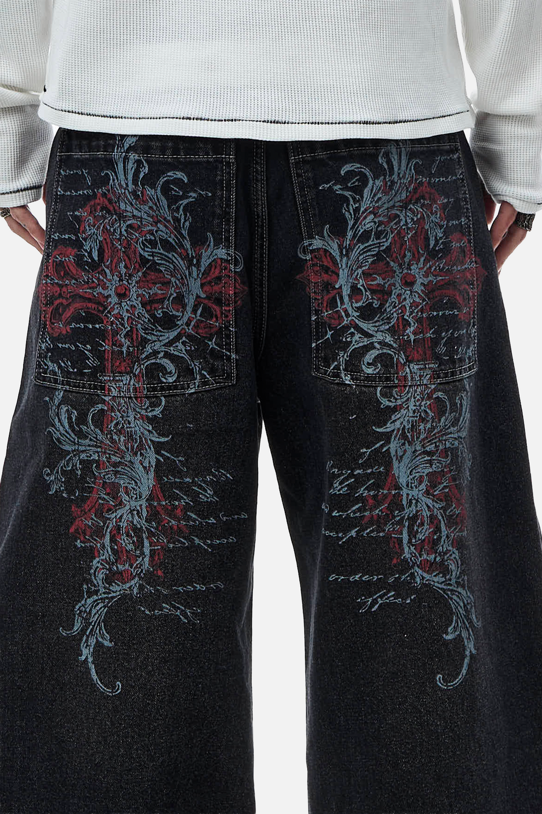 Close-up of the Blessed Outlaw Denim back pockets with red crosses and blue scrollwork