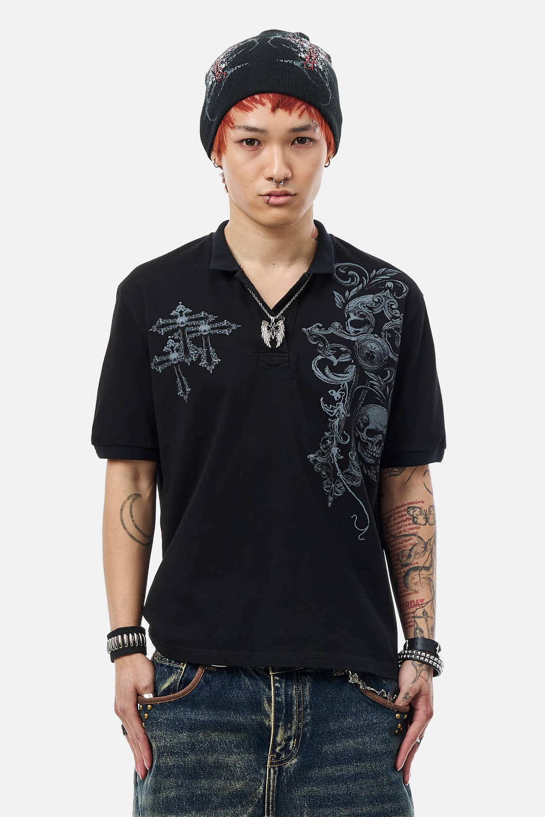 Model in a beanie wearing the black Skull Garden Polo with gray skull and cross print