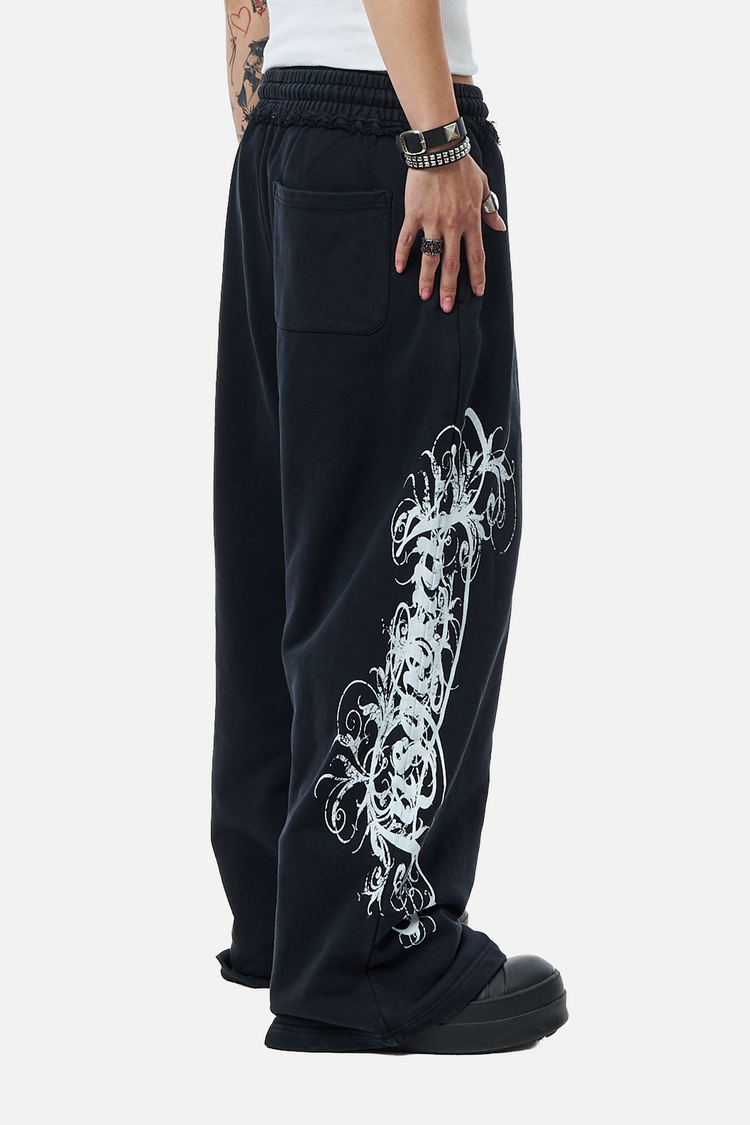 Side view of the black Eternal Sweatpants showing the white gothic script print down the leg