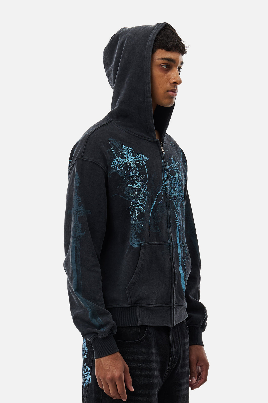Side view of the Blade Hoodie with hood up, showing blue cross print on the sleeve