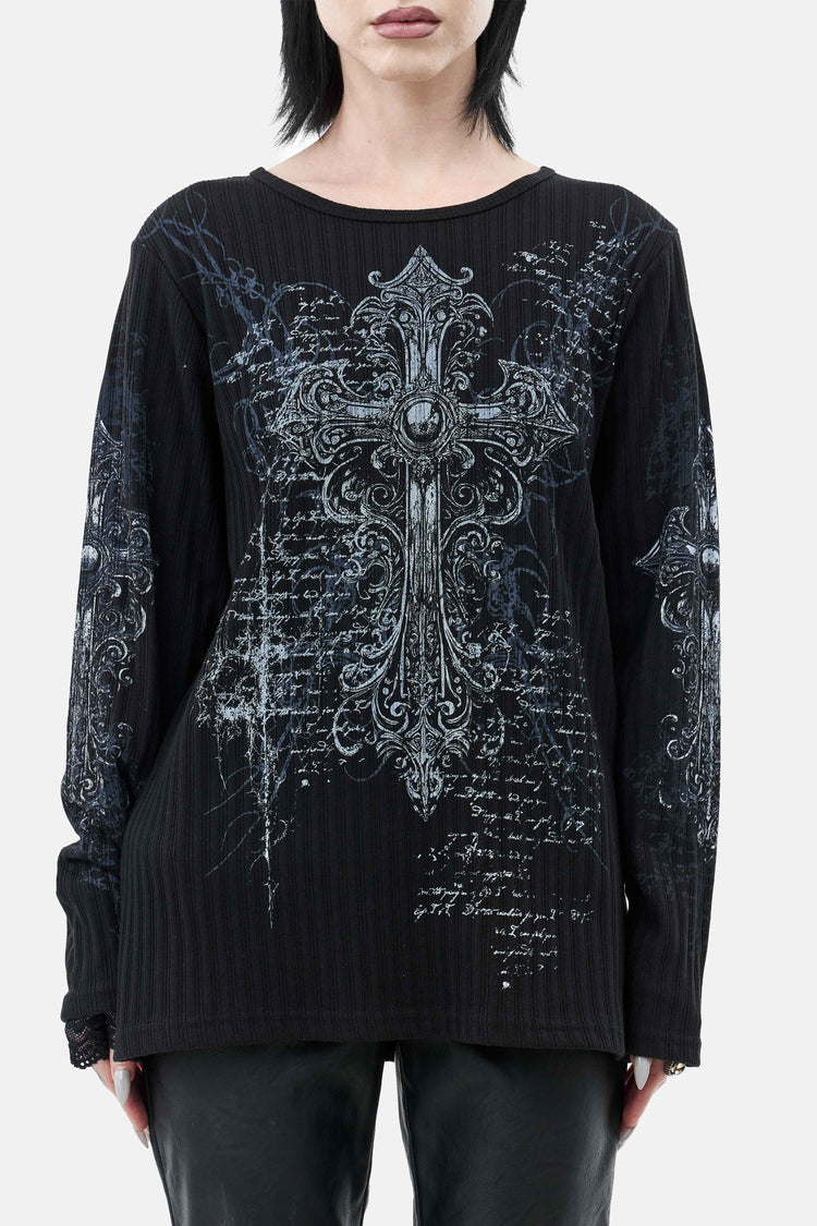 Close-up front of the Scripture Ribbed Long Sleeve's ornate cross graphic on ribbed black knit