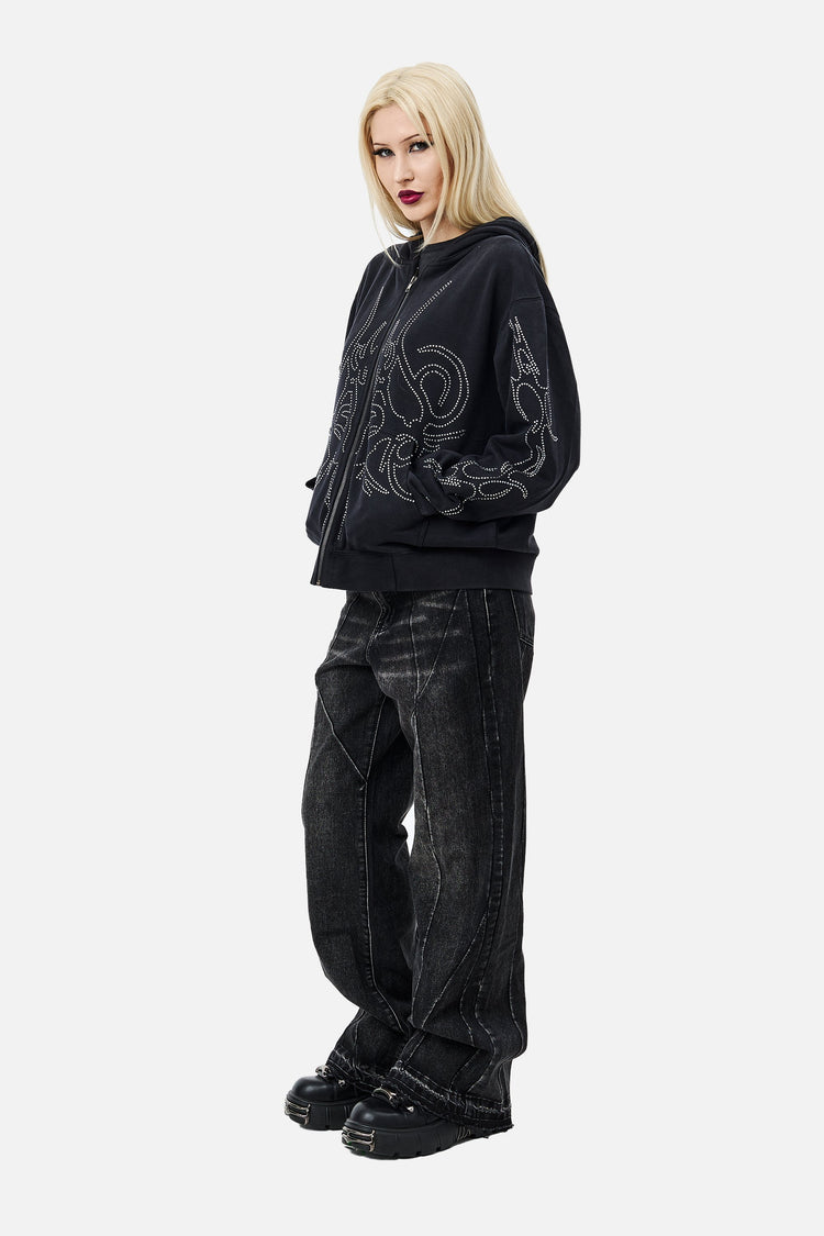 Side view of the Sigil Rhinestone Zip Hoodie styled with black jeans, full length