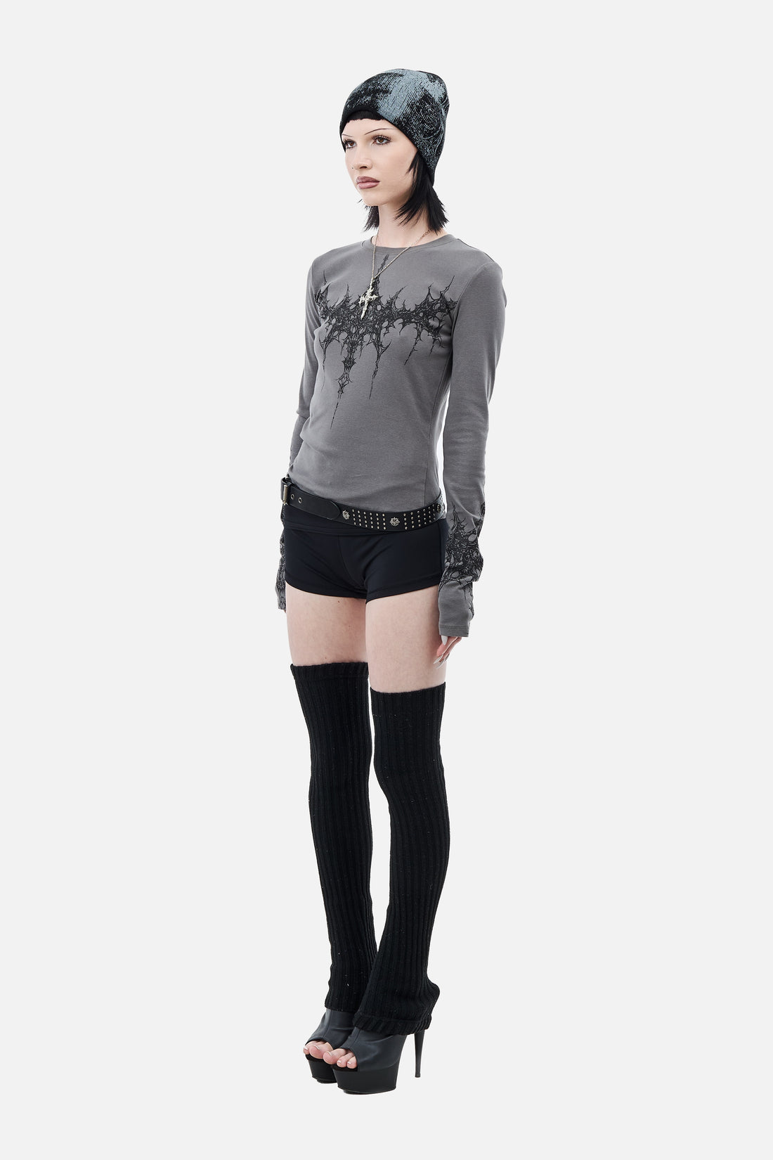 Side view of the fitted gray Tribal Longsleeve with black shorts and platform heels