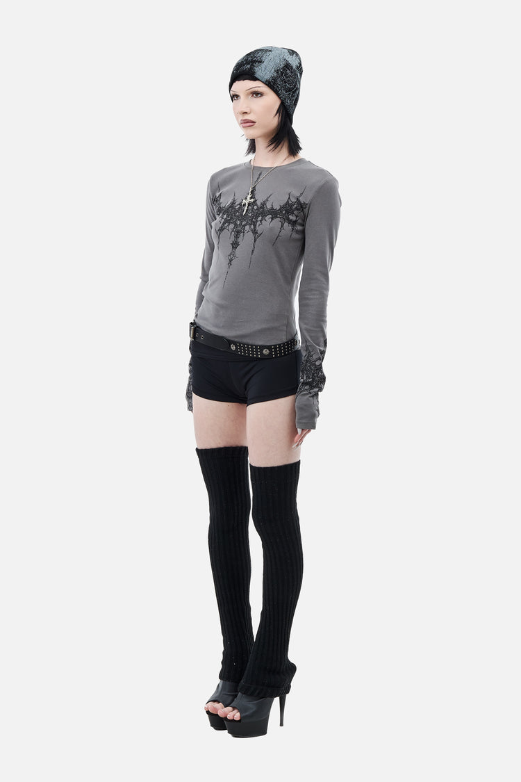 Side view of the fitted gray Tribal Longsleeve with black shorts and platform heels