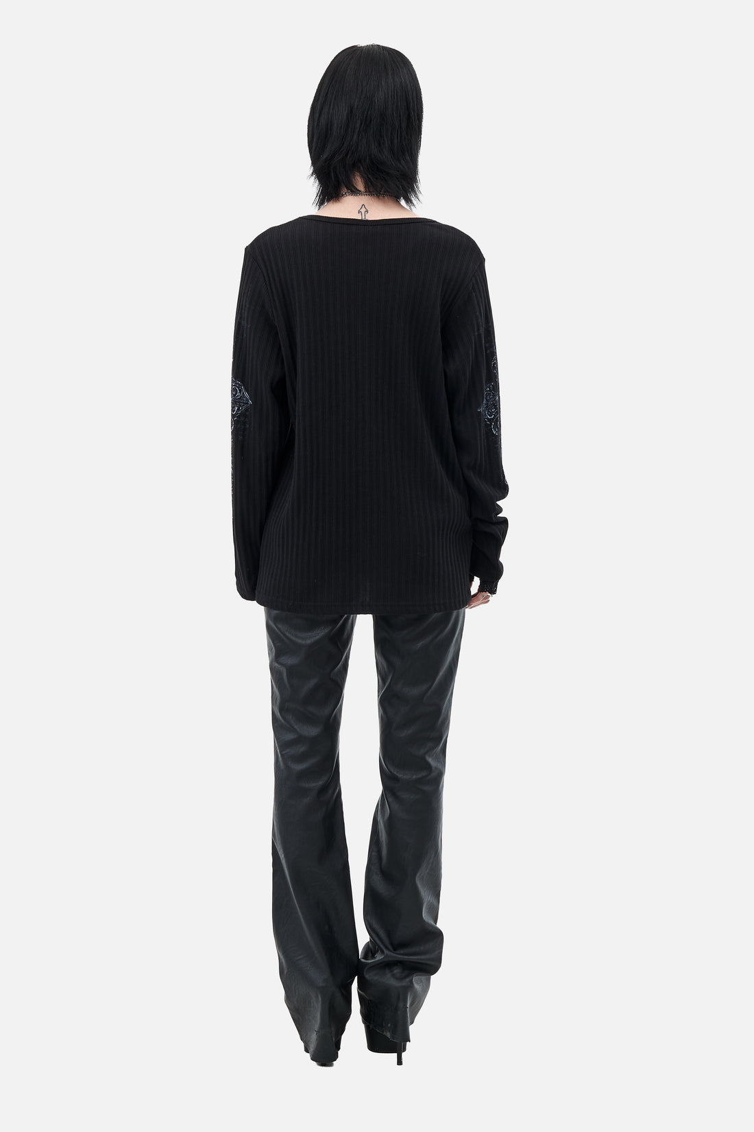 Full-length back view of the Scripture Ribbed Long Sleeve with black leather pants