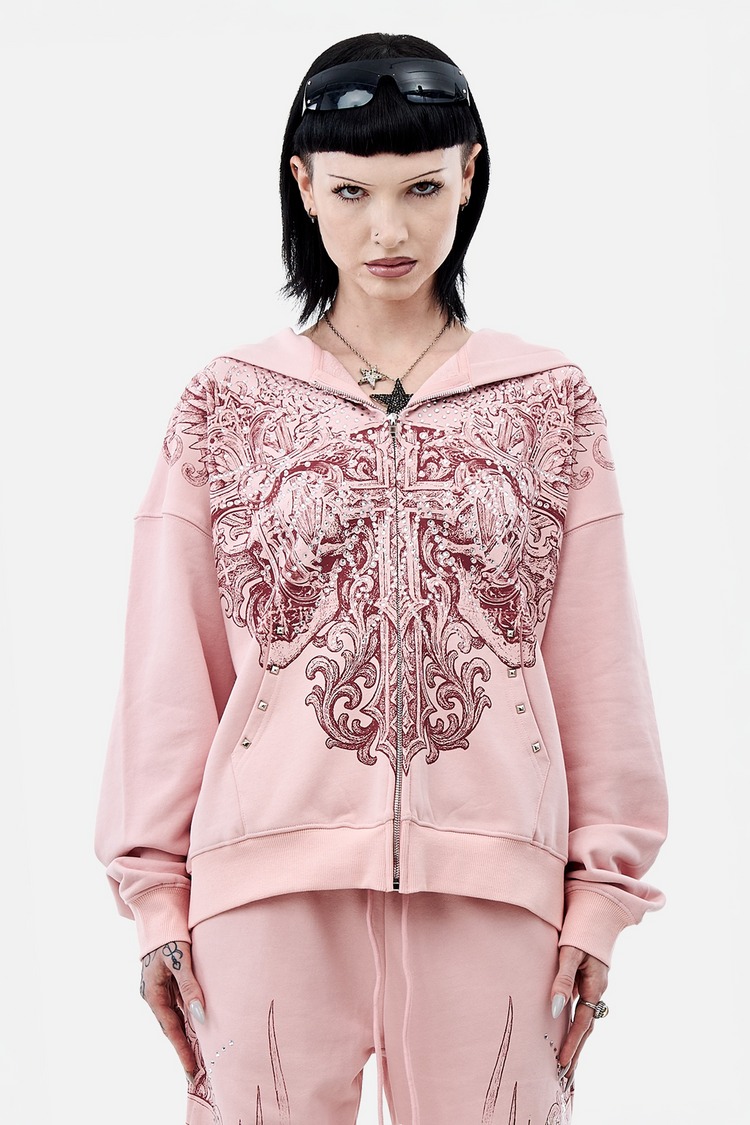 Model wearing the pink Bonnie Hoodie with burgundy winged skull print and matching pants, front view