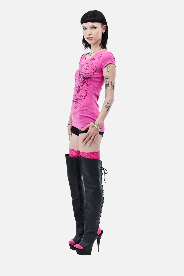 Side view of the fitted pink Lovers V-Neck T-Shirt with shorts and lace-up heeled boots