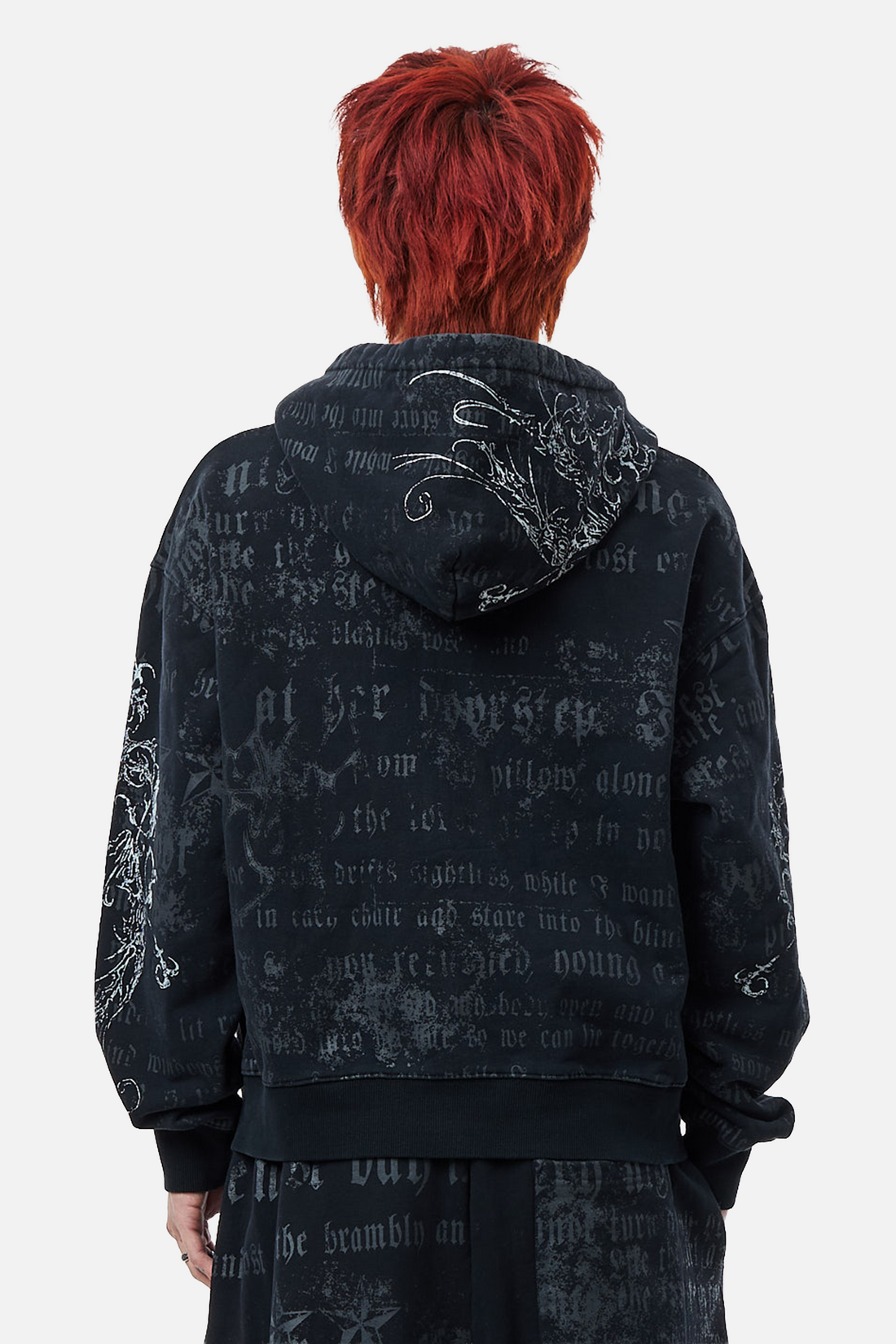 Back view of the Sacred Zip Hoodie showing the faded gothic script print and hood embroidery