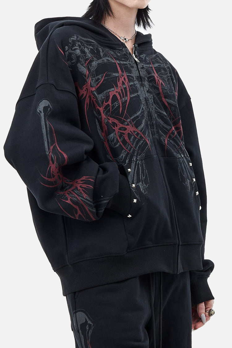 Angled close-up of the Skeleton Hoodie showing stud details and red thorn sleeve print