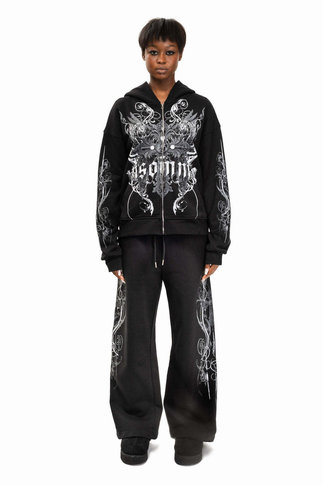 Model wearing the black Crux Hoodie with black wide-leg pants, full-length front view