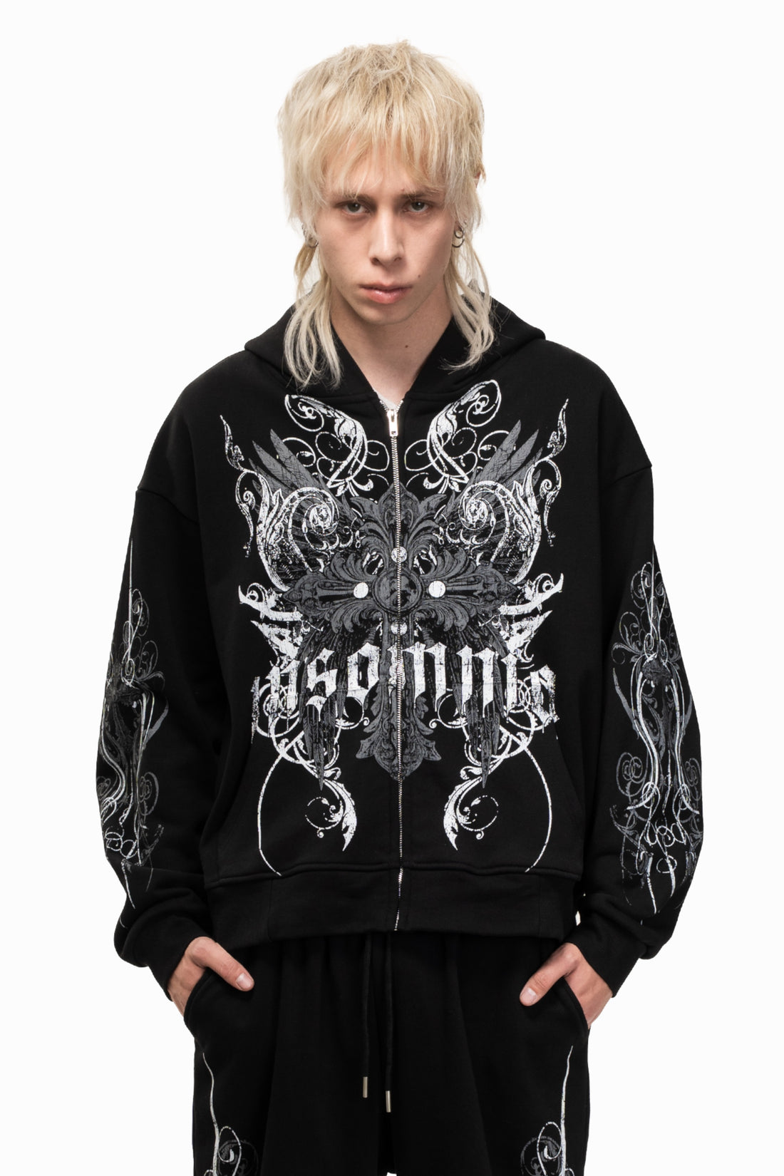 Model wearing the black Crux Hoodie zipped, front close-up of the white gothic graphic