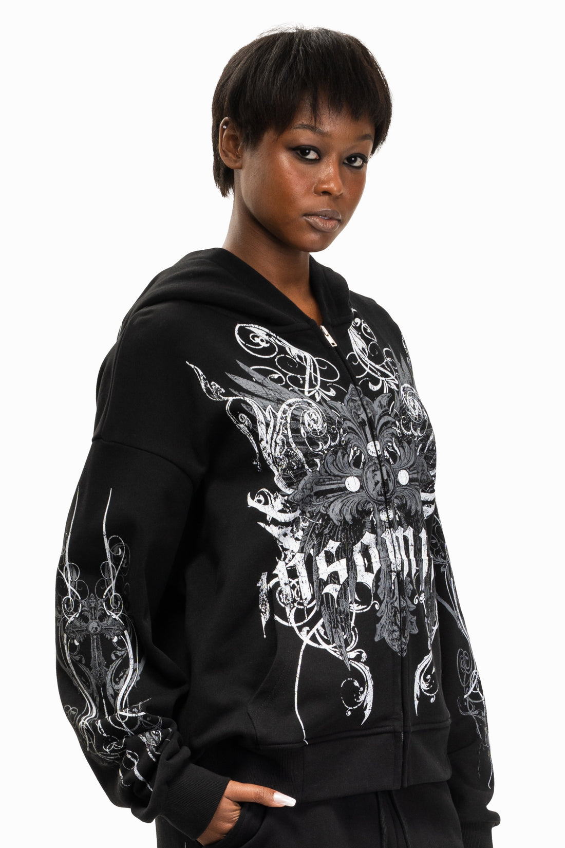 Model in the black Crux Hoodie with hood down, three-quarter view of the print