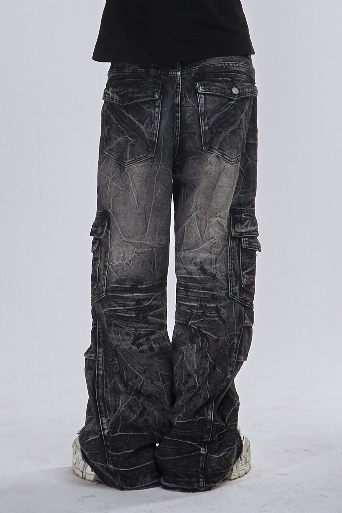 Back view of the Fractured Denim showing the faded wash, flap pockets and stacked legs