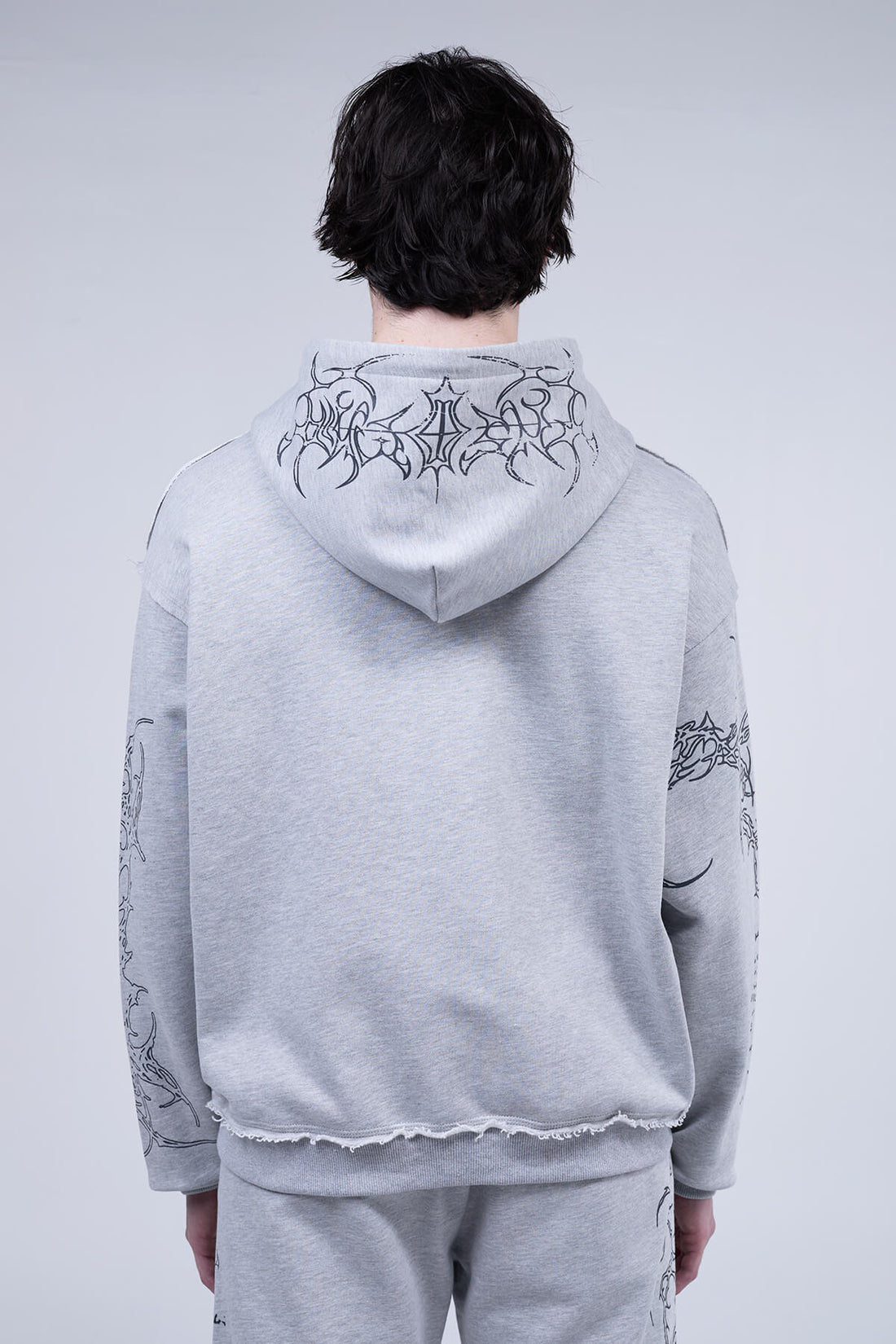Back view of the Gray Sigil Zip Hoodie showing the tribal graphic across the hood