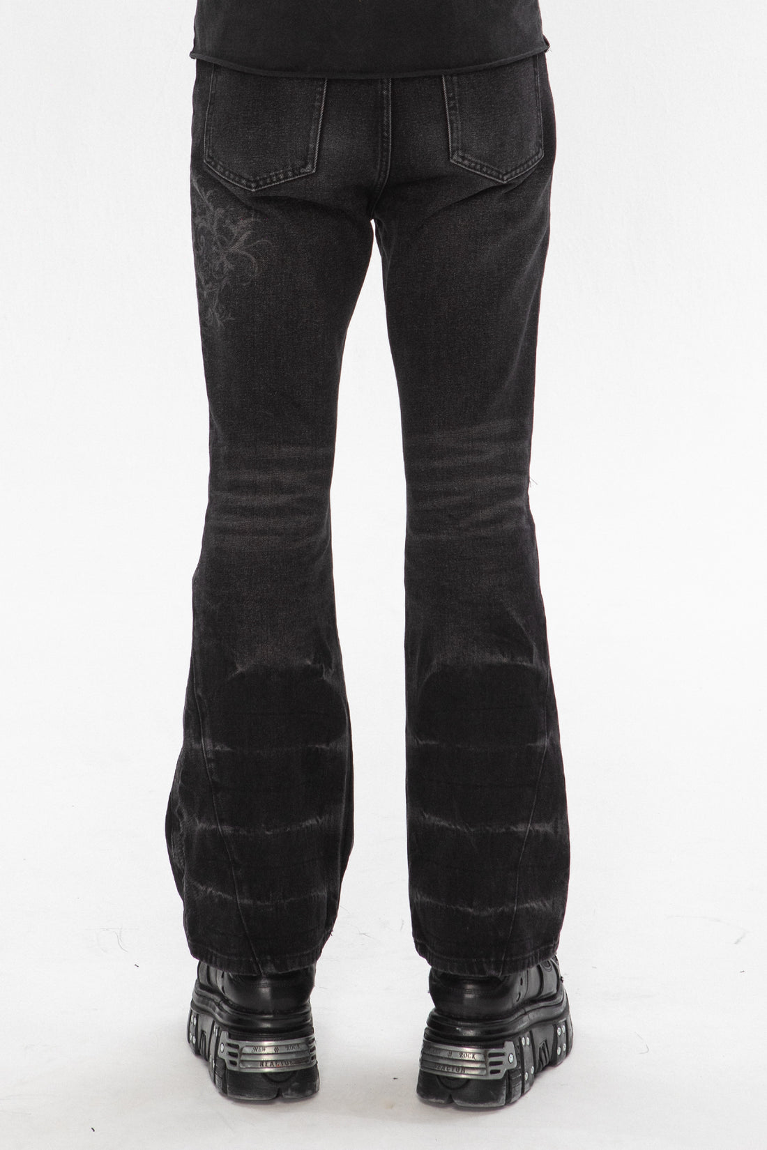 Back view of the Thorns Flared Denim showing the embroidered thorn detail and flared hems