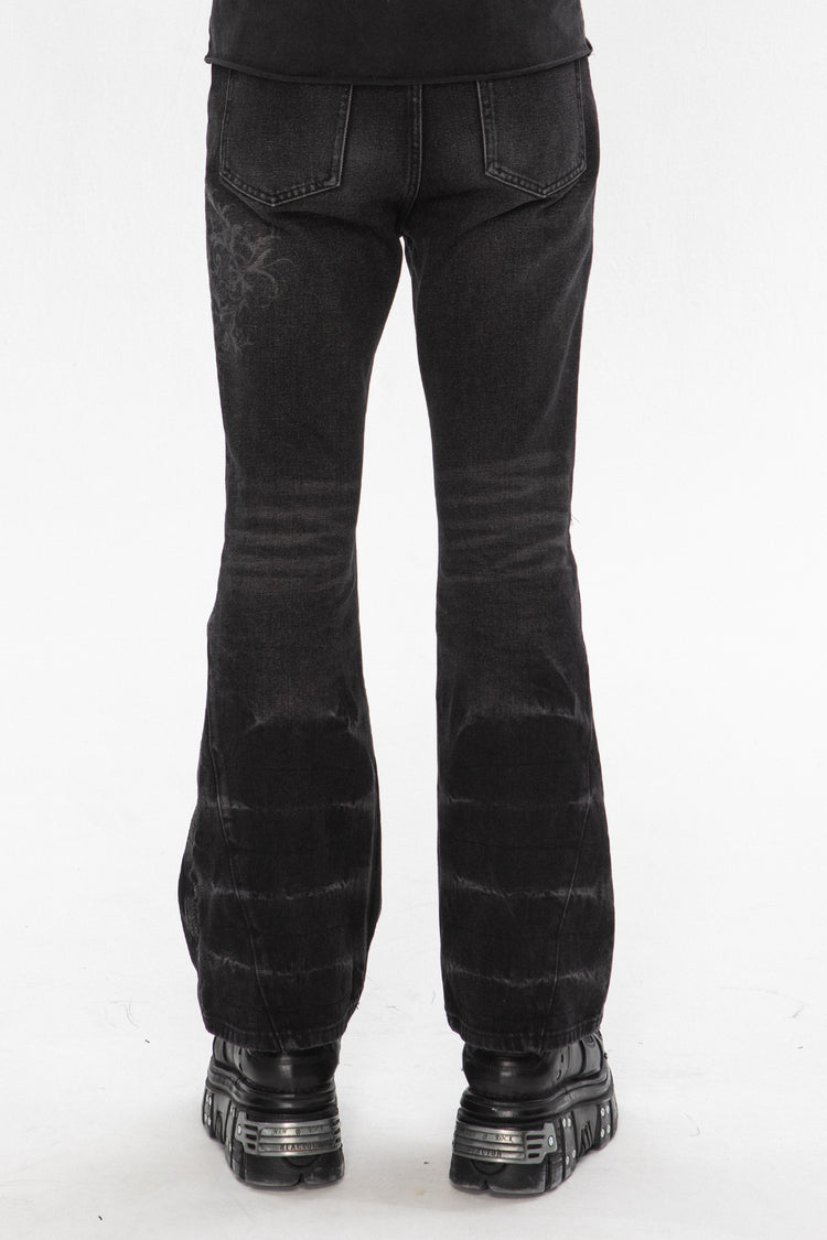 Back view of the Thorns Flared Denim showing the embroidered thorn detail and flared hems