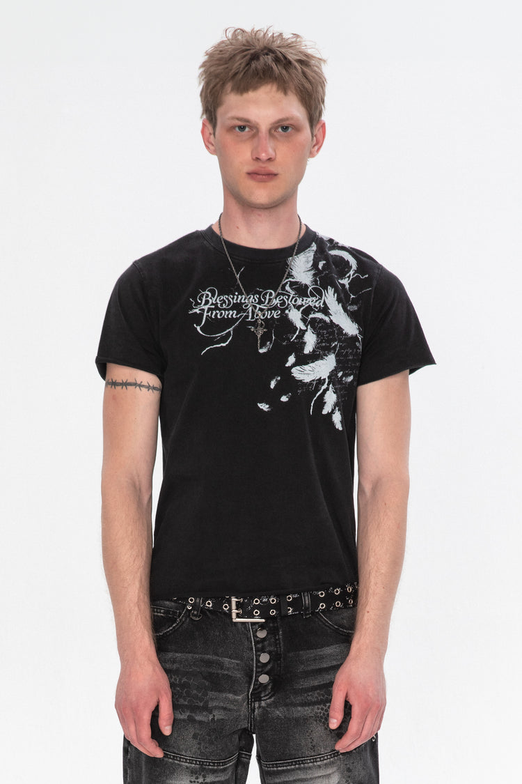 Model wearing the Black Feather Tee with white feather and script print over one shoulder, front view