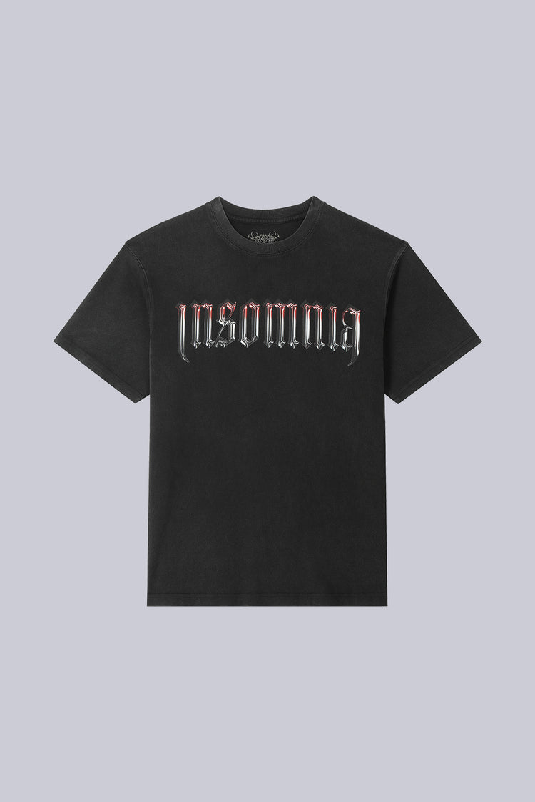 Front of the washed black Cross Tee laid flat, with chrome Insomnia gothic lettering