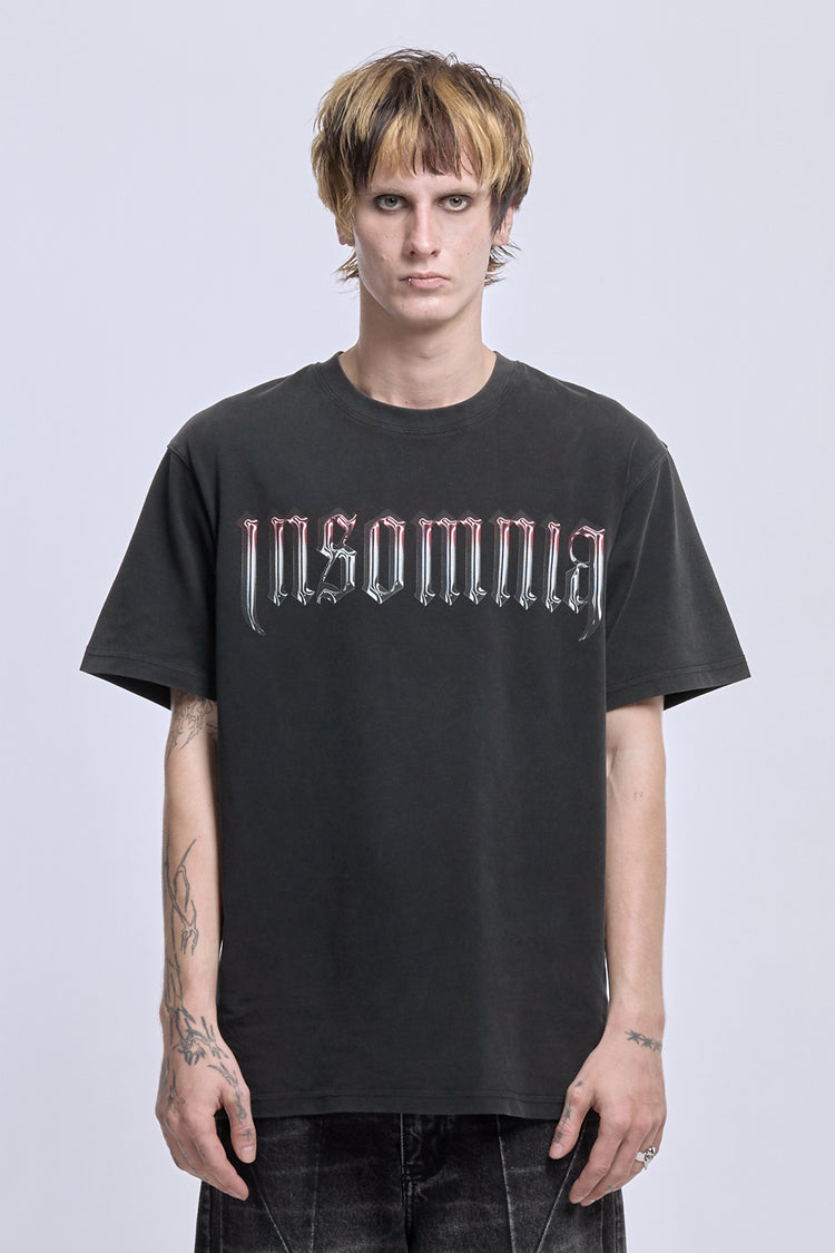 Model wearing the washed black Cross Tee with chrome Insomnia gothic logo, front view