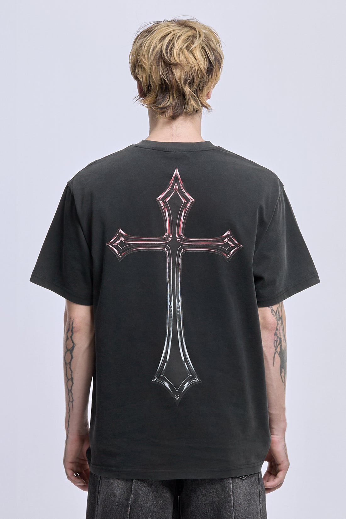 Back view of the washed black Cross Tee on model, showing the large chrome cross print