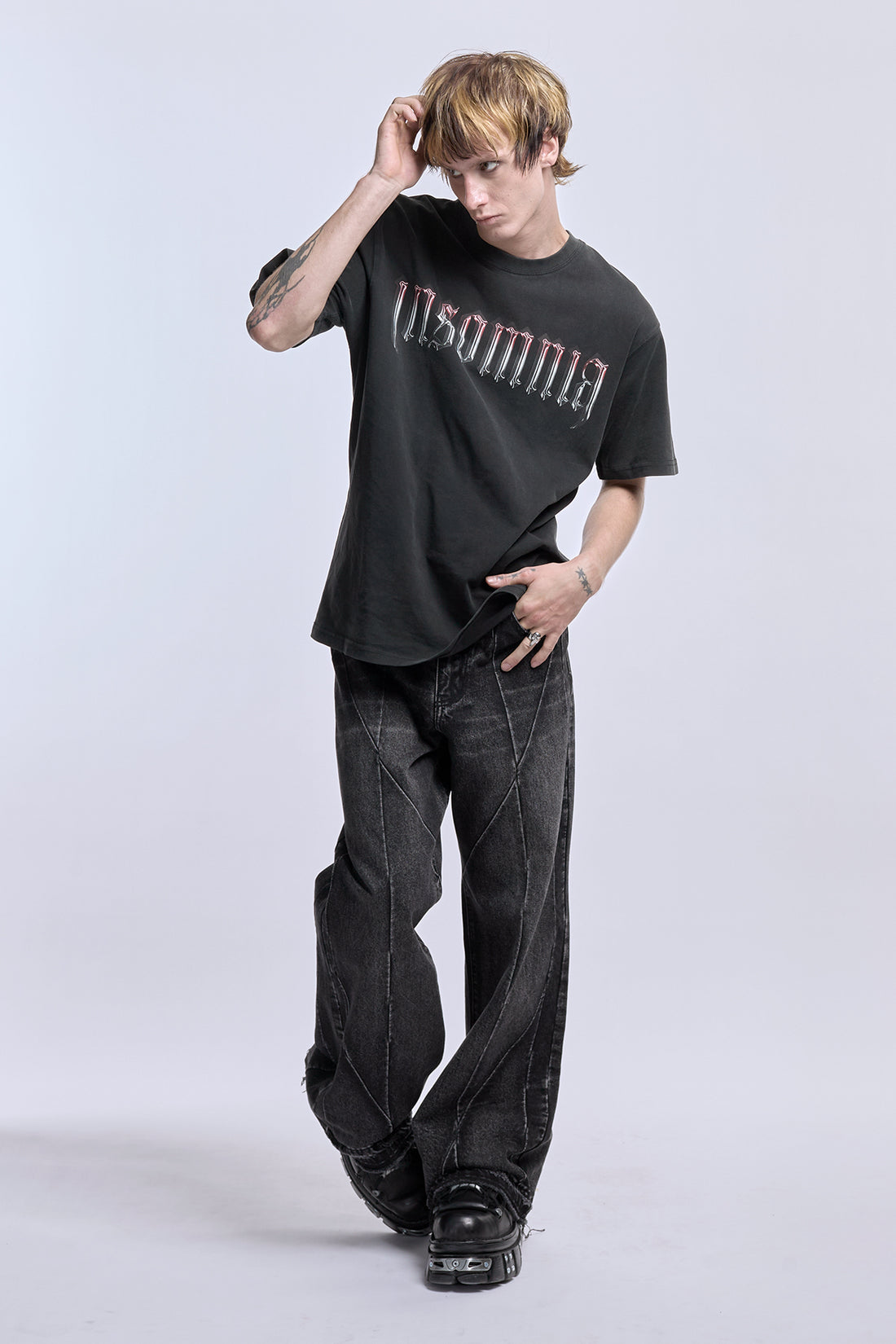 Full-length view of the Cross Tee with black baggy jeans, Insomnia logo on front