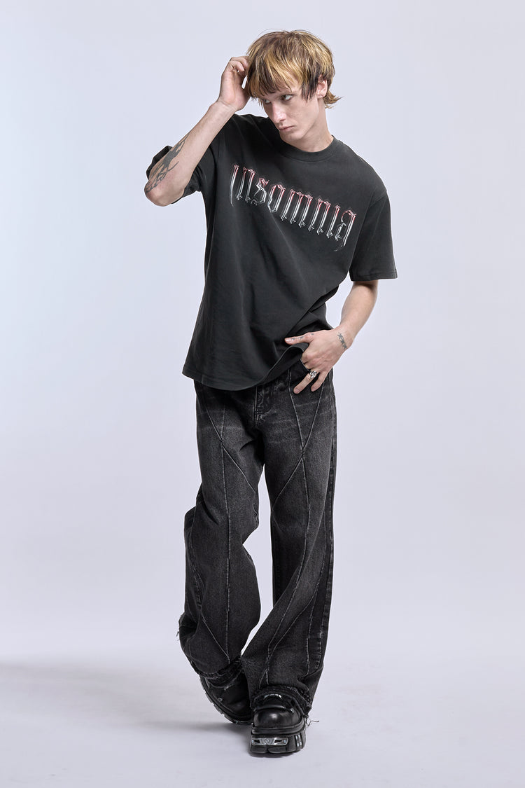 Full-length view of the Cross Tee with black baggy jeans, Insomnia logo on front