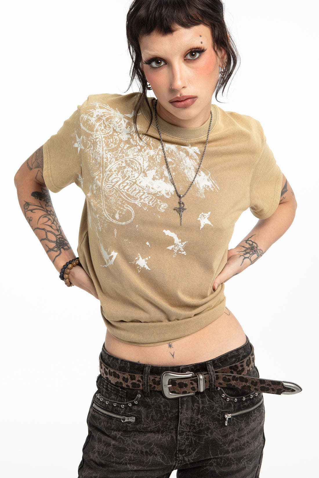 Model wearing the Cheetah Belt with a cropped tan graphic tee and black acid-wash jeans