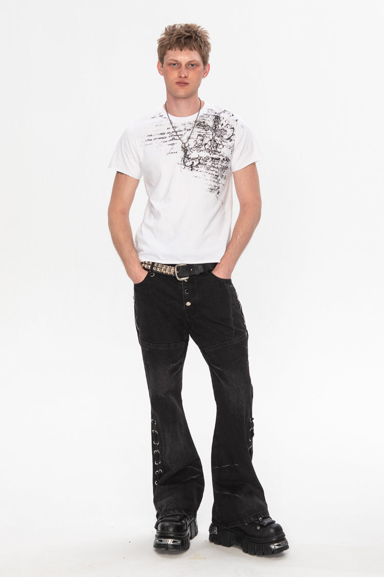 Full-length view of the white Orison Tee worn with black flared jeans and boots