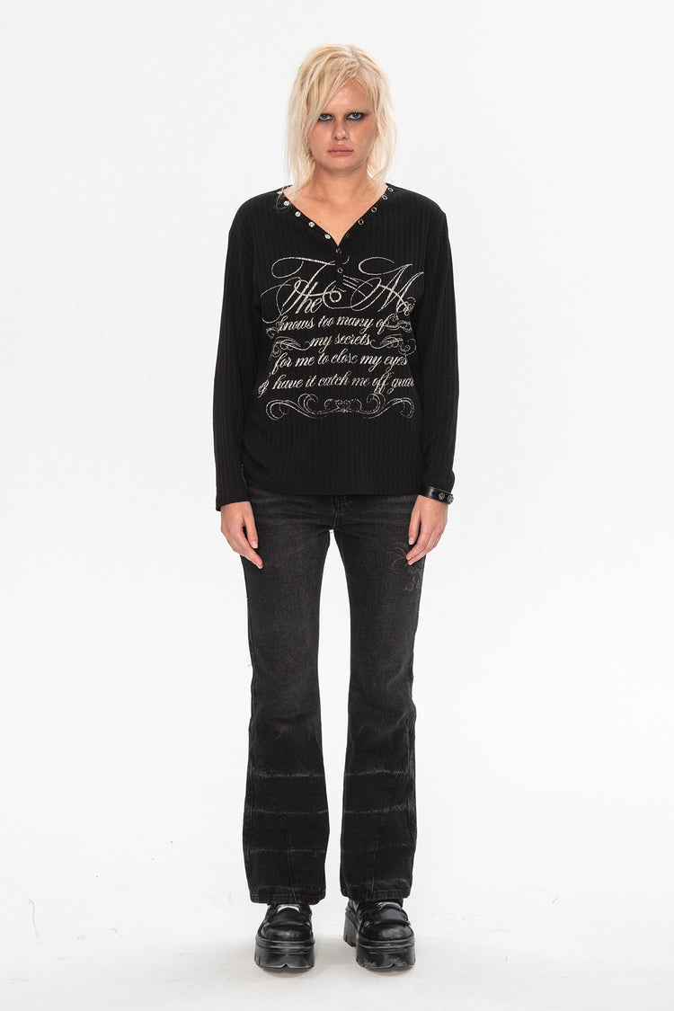 Full-length view of the Thorns Flared Denim with a black script print longsleeve