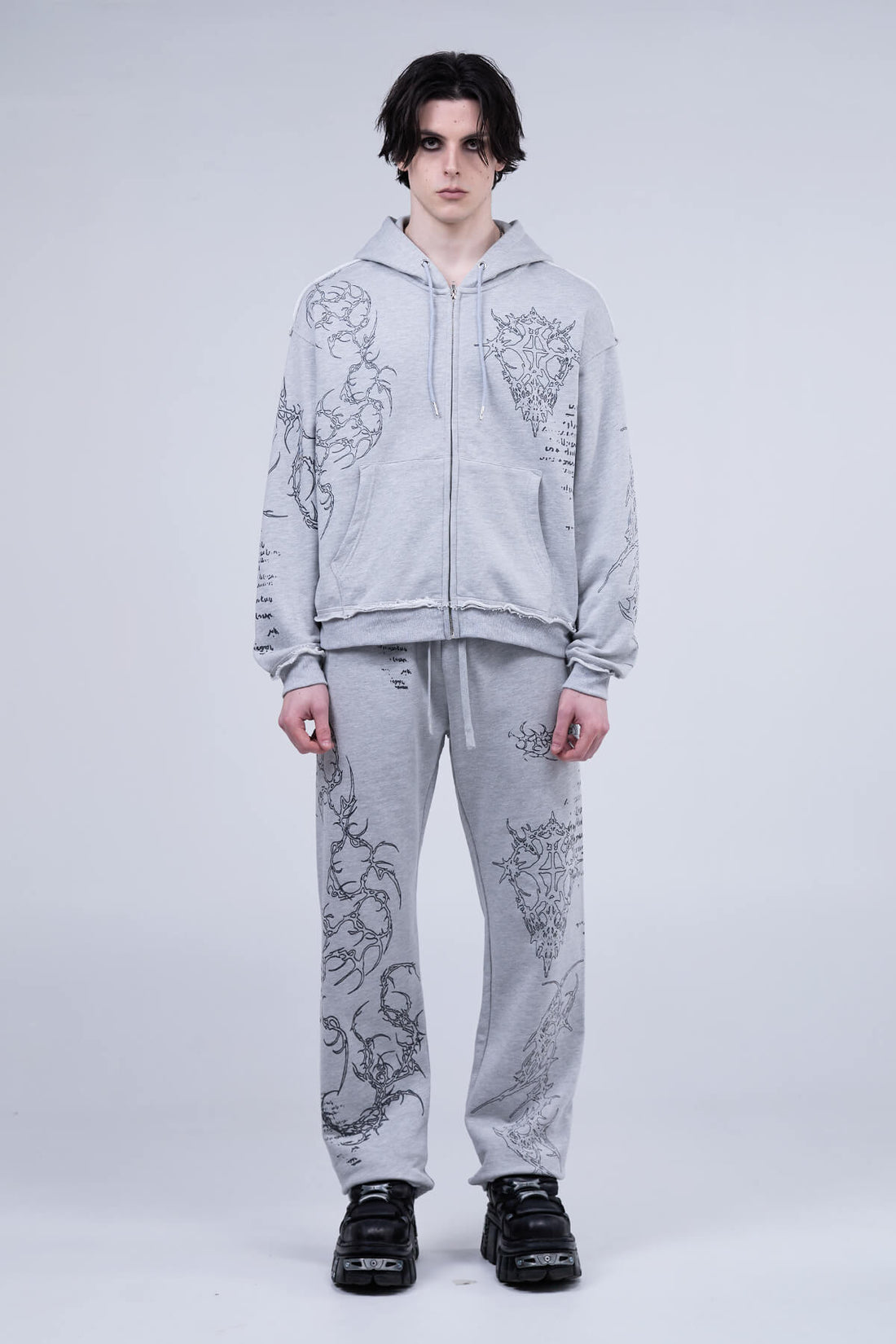 Full-length view of the Gray Sigil Zip Hoodie with matching sweatpants and black sneakers